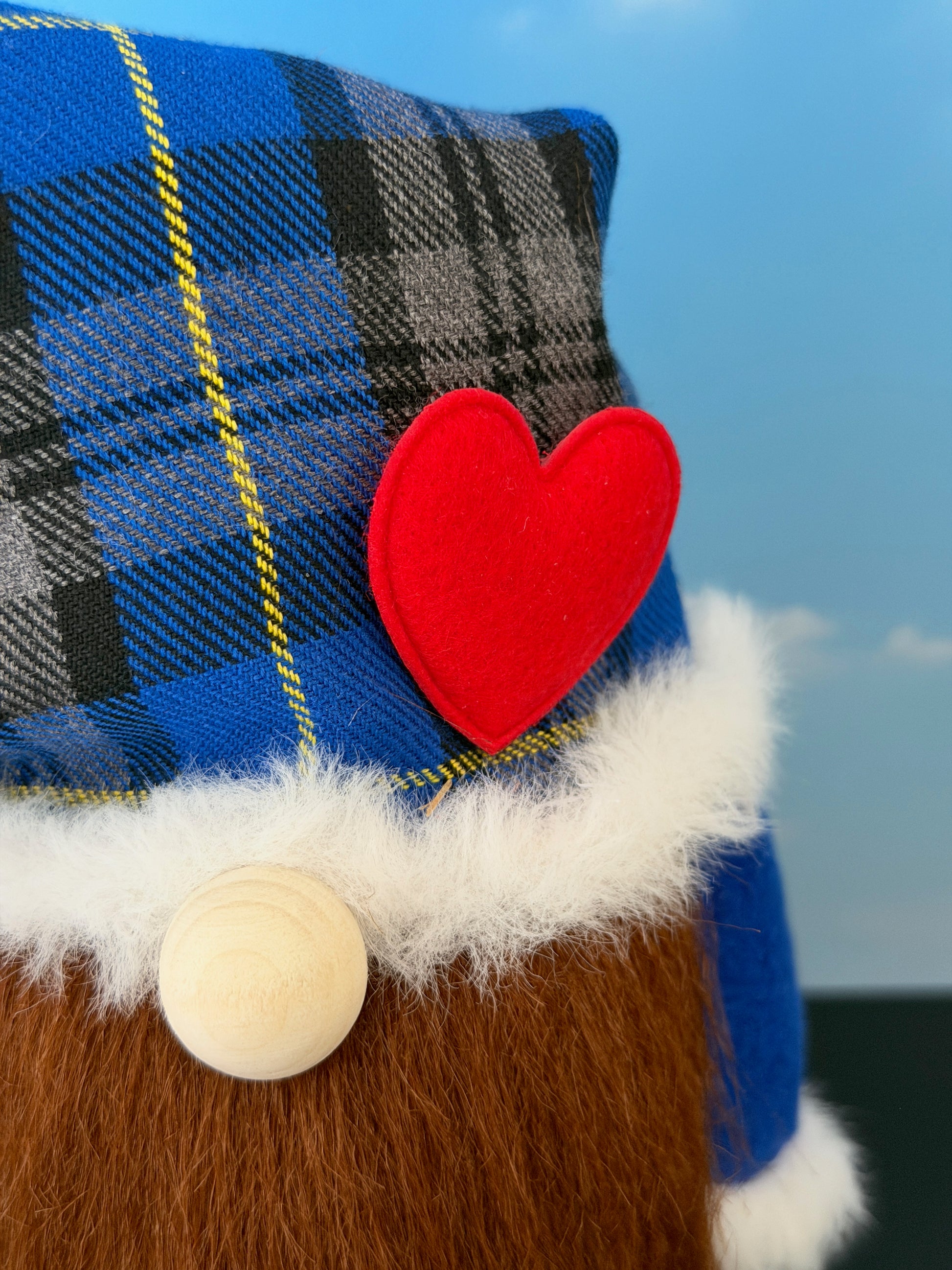 Close-up of handmade gnome details including tartan hat, faux fur trim, heart-shaped nose and character beard.